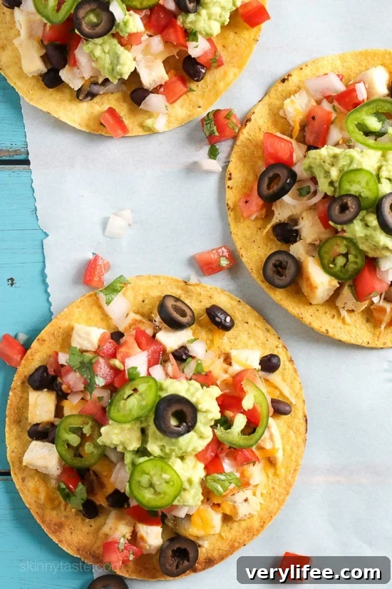 Crispy Nacho-Style Chicken Tostada with Melted Cheese 3 Loaded nacho chicken tostada with fresh toppings.