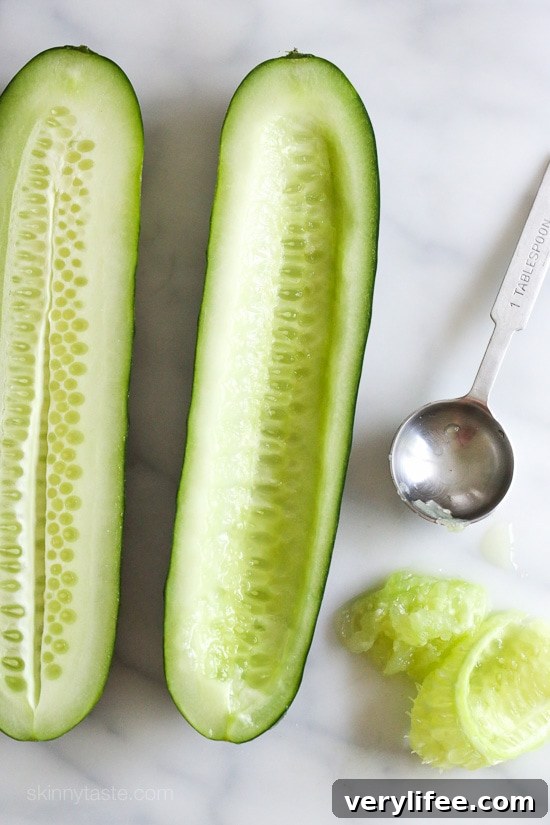 Two cucumber boats filled with hummus and colorful vegetables, ready to serve.