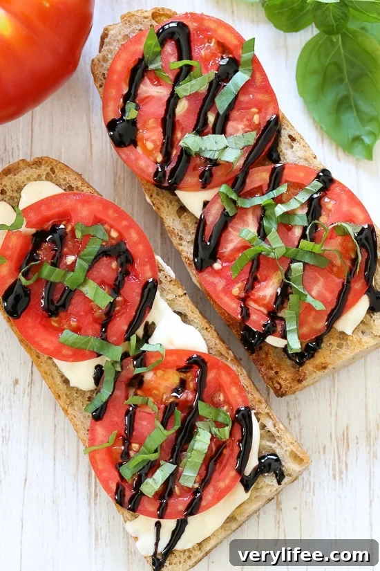 Caprese French Bread Pizza with Fresh Basil and Mozzarella 3 French Bread Caprese pizzas on a cutting board