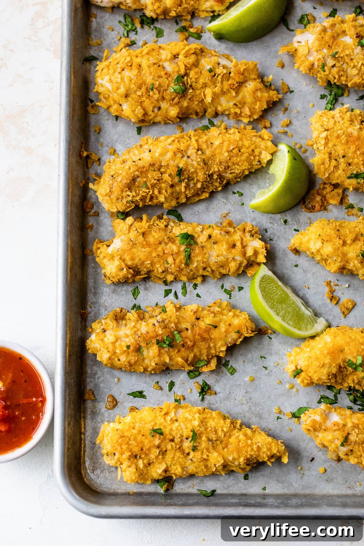 Crispy Tortilla-Crusted Chicken Tenders 3 Tortilla Encrusted Chicken Tenders with lime wedges