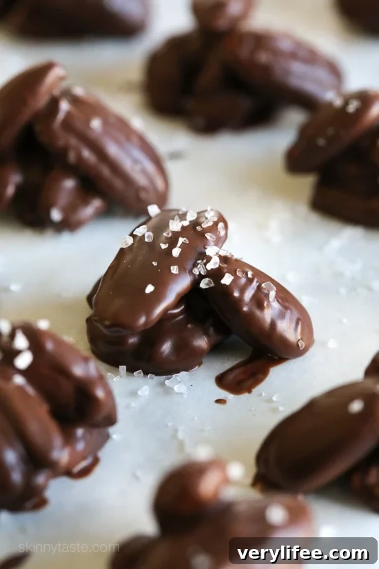These easy 5-ingredient nut clusters are made with almonds, pecans and walnuts dipped in dark melted chocolate and finished with a touch of sea salt for the tastiest and healthy-ish Holiday treat!
