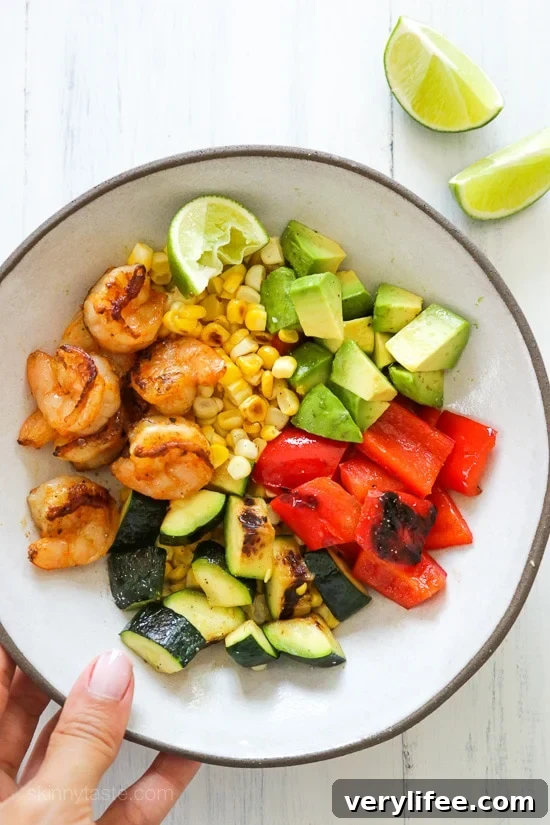 Grilled shrimp, corn, peppers and zucchini topped with fresh avocado and lime juice – an easy light salad you'll want to make all summer long.
