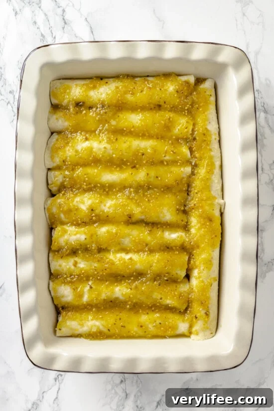 Salsa verde poured over enchiladas