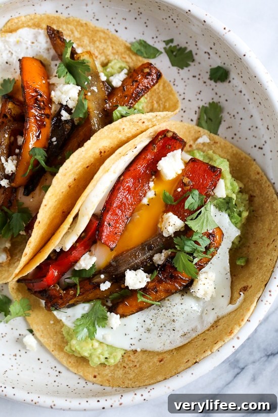 Close-up of breakfast fajitas with peppers and onions, guacamole and a runny egg