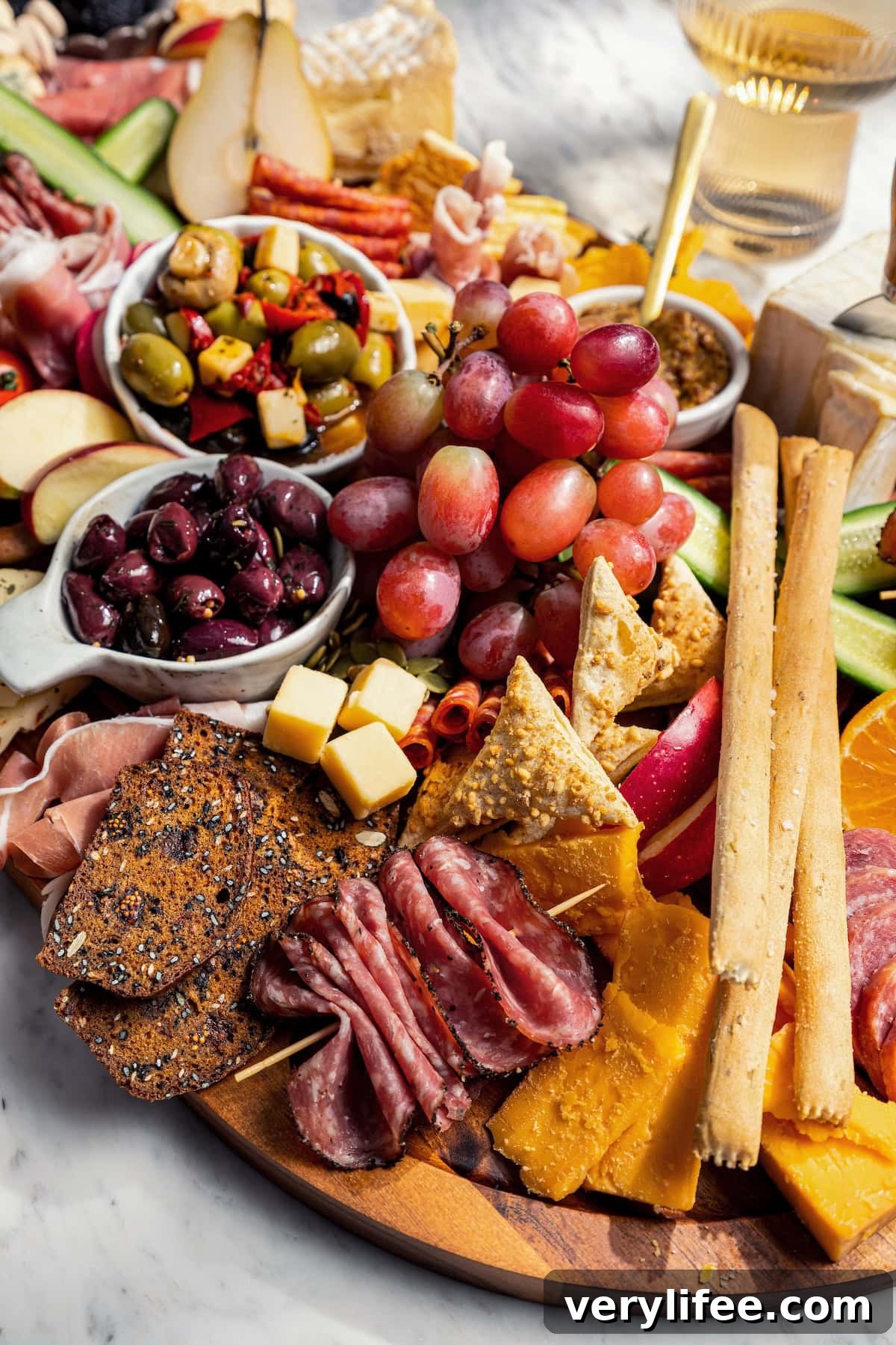 Charcuterie board with cheese, meat, fruit, olives, and more.