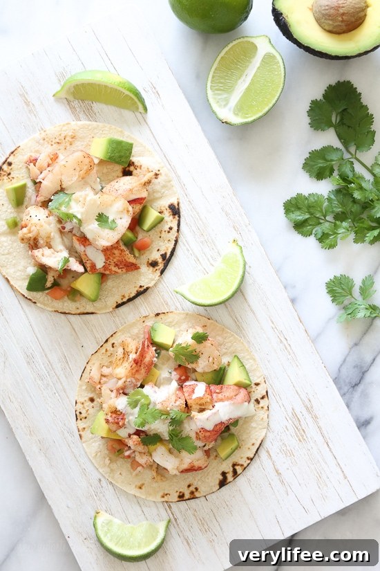 Lobster tacos served with lime wedges and microgreens