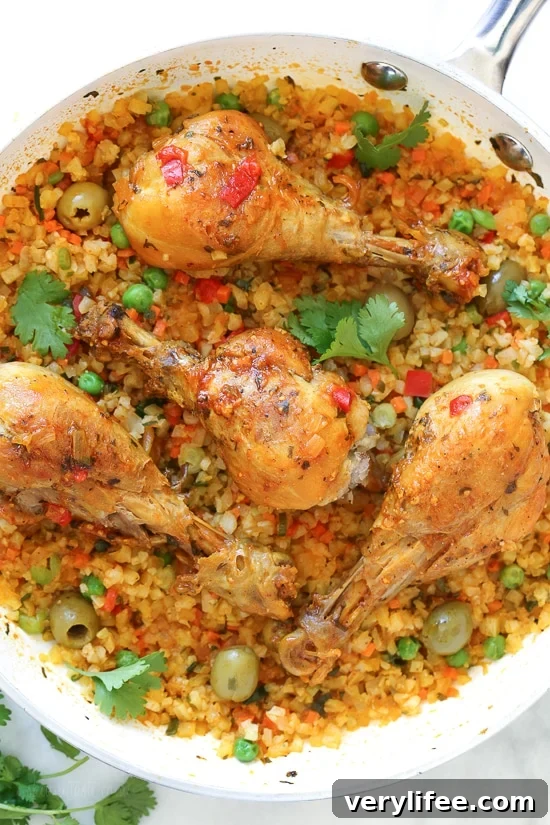 Skillet Cauliflower "Arroz" Con Pollo (Spanish chicken and rice) uses cauliflower rice as a low-carb swap, which means larger portions with 85% less calories than rice!