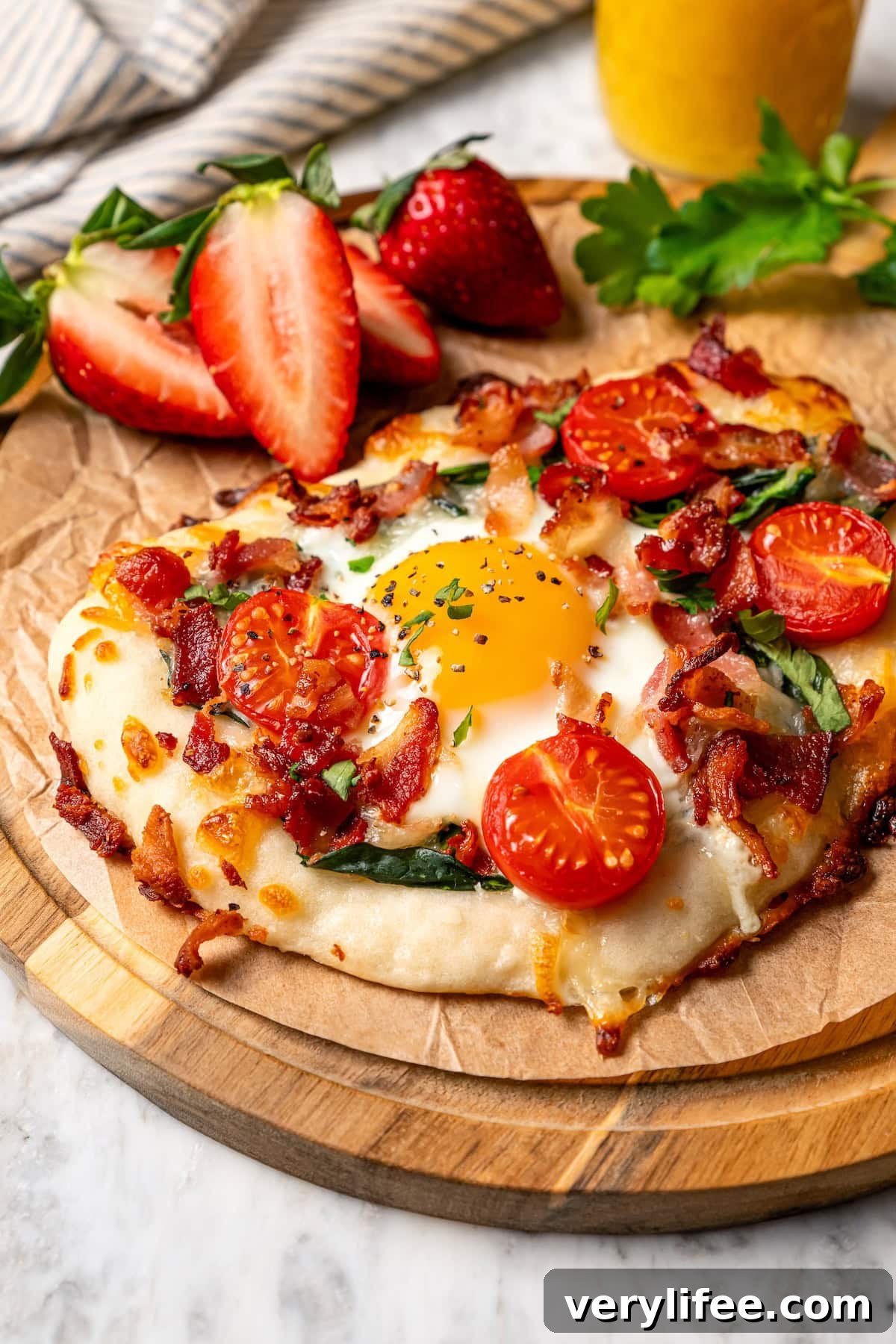 High-Protein Breakfast Pizza Recipe 9 Breakfast pizza topped with egg, tomatoes, spinach, and bacon.