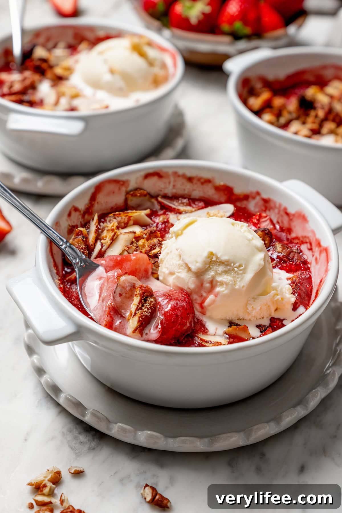 Homemade Strawberry Crisp Recipe with Oat Streusel 11 Strawberry crisp in bowl with scoop of ice cream and spoon