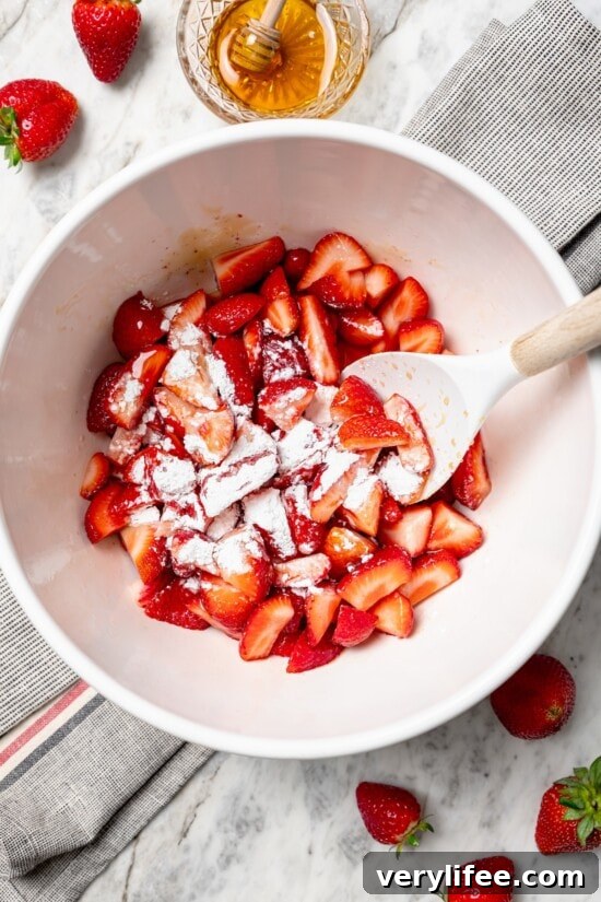 Homemade Strawberry Crisp Recipe with Oat Streusel 6 Stirring cornstarch into strawberries in bowl