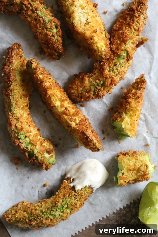 Crispy baked avocado fries coated with panko breadcrumbs with a lime dipping sauce. So fast and easy to make in the oven or air fryer!