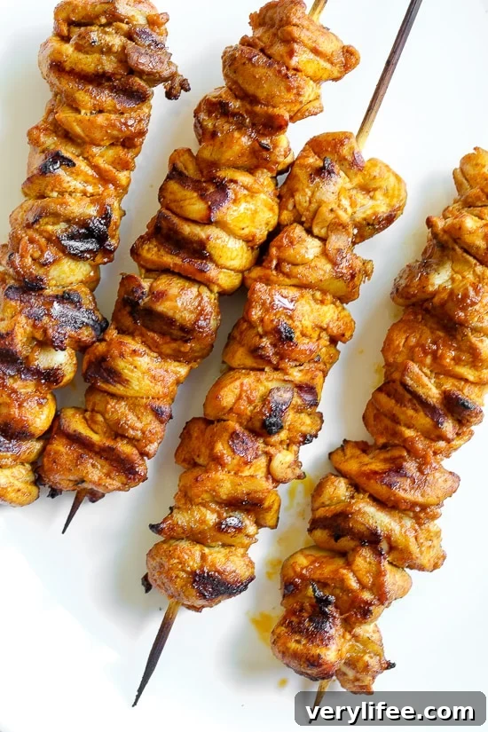 Grilled chicken shawarma skewers resting on a plate.