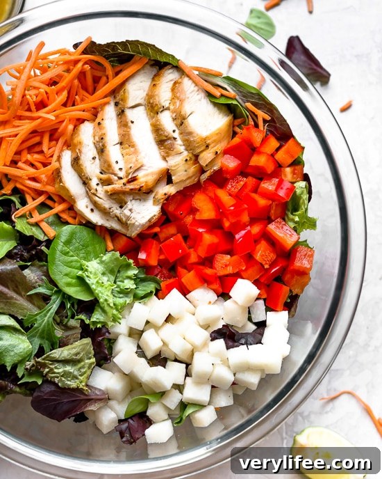 Grilled Chicken Salad with greens and vegetables are tossed in a honey-lime vinaigrette and topped with a delicious peanut sauce.