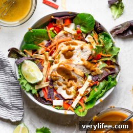 Grilled Chicken Salad with greens and vegetables are tossed in a honey-lime vinaigrette and topped with a delicious peanut sauce.