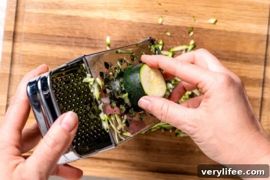 Grating zucchini on box grater.