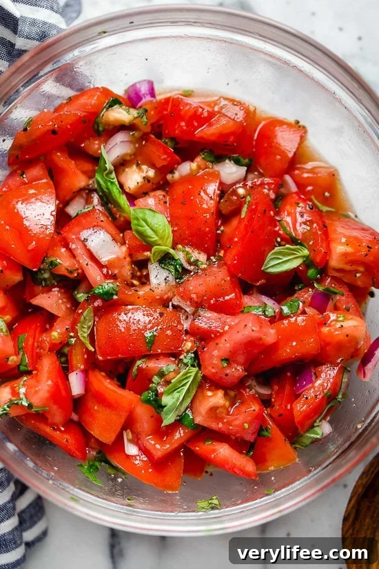 Fresh Summer Tomato Salad with Basil and Olive Oil 6 Summer tomato salad in glass bowl with fresh basil and seasonings.
