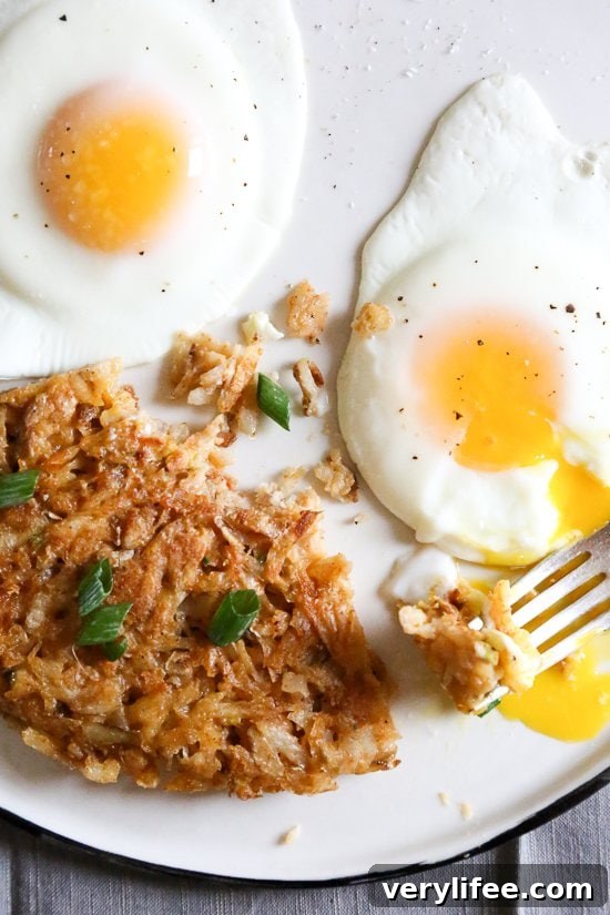 Overhead view of hash browns on plate with fried eggs