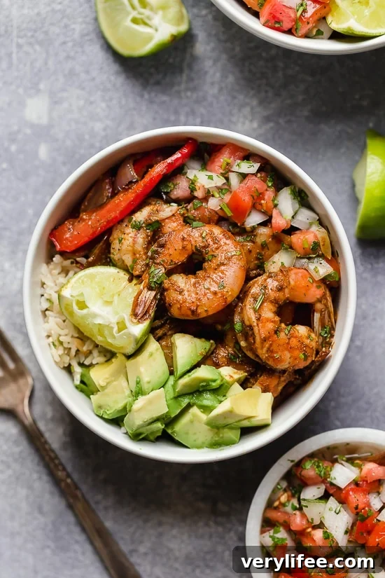 Shrimp fajita bowls served over cilantro-lime rice with peppers, onions, avocado and salsa.