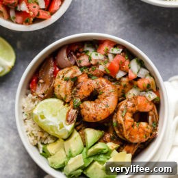 Finished shrimp fajita bowl with rice, shrimp, peppers, salsa and avocado.