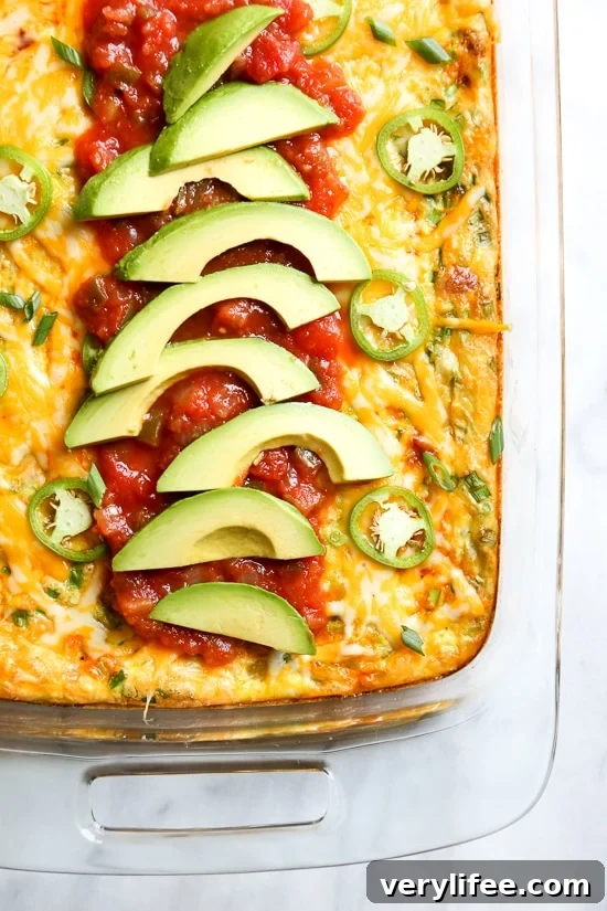 Tex Mex breakfast casserole with potatoes, chorizo, green chiles and cheese, topped with salsa and avocado
