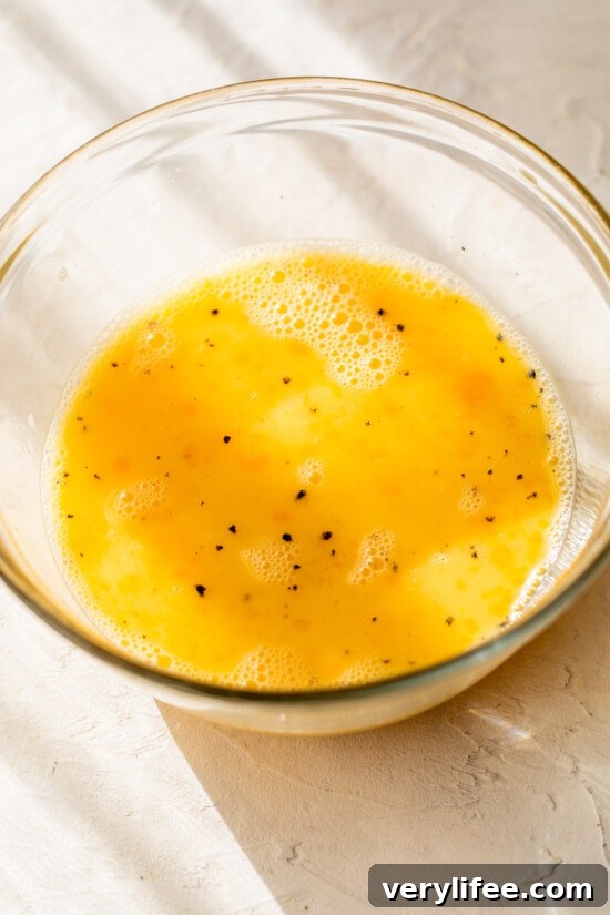 Eggs mixed with salt and pepper in bowl