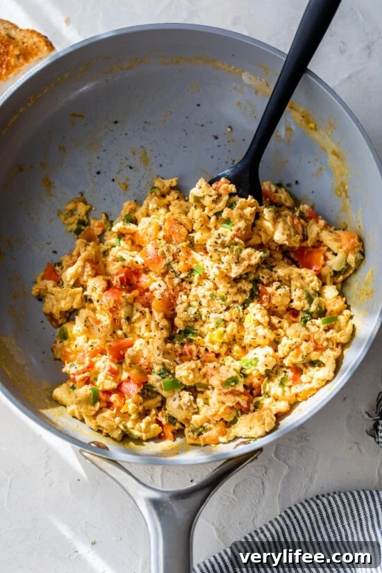 Huevos Pericos in skillet with spatula