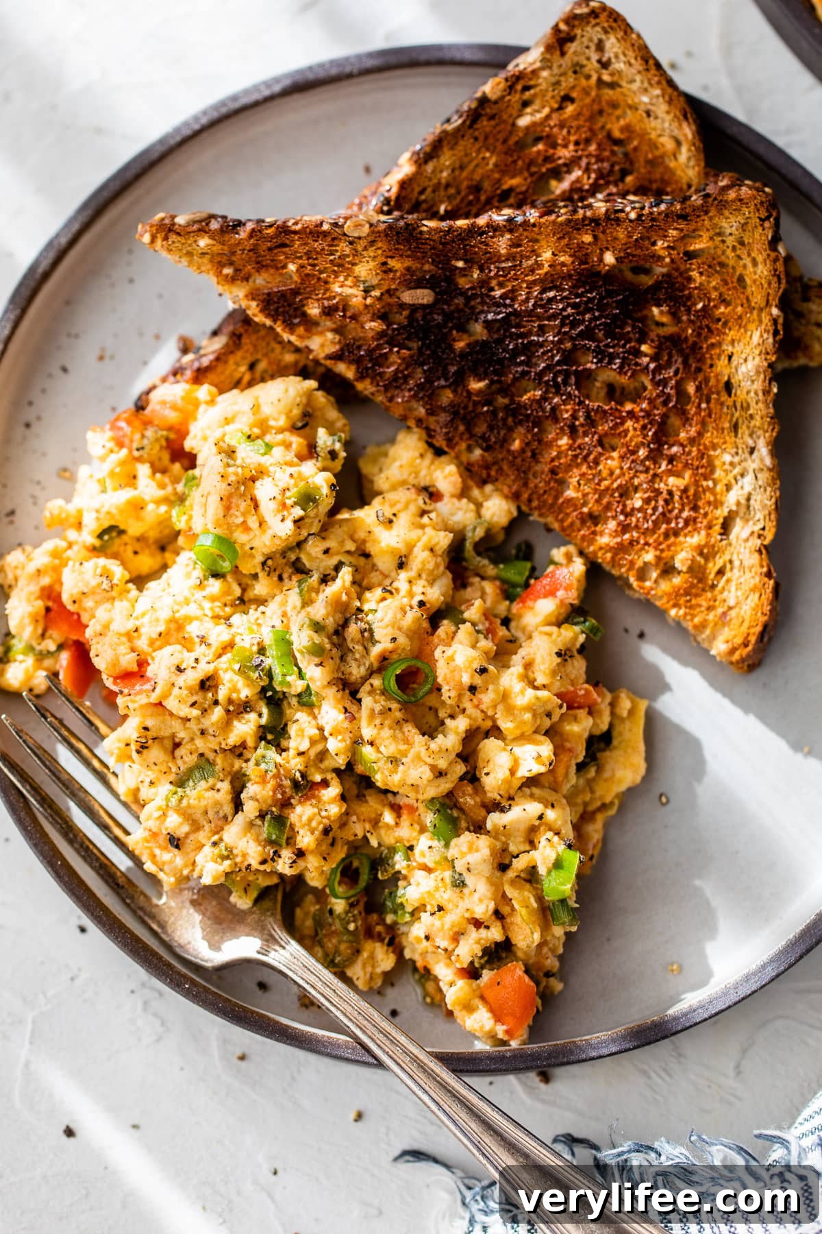 Huevos pericos on plate with two slices of toast and fork