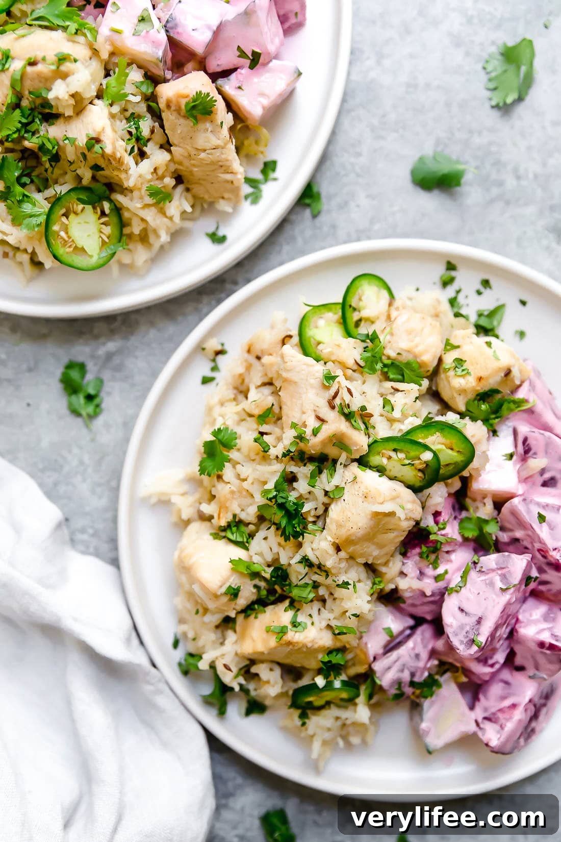 Instant Pot Chicken Pulao comes together in just 30 minutes, with basmati rice, chicken breasts, and a few aromatics and spices. Overhead view of two plates of chicken pulao