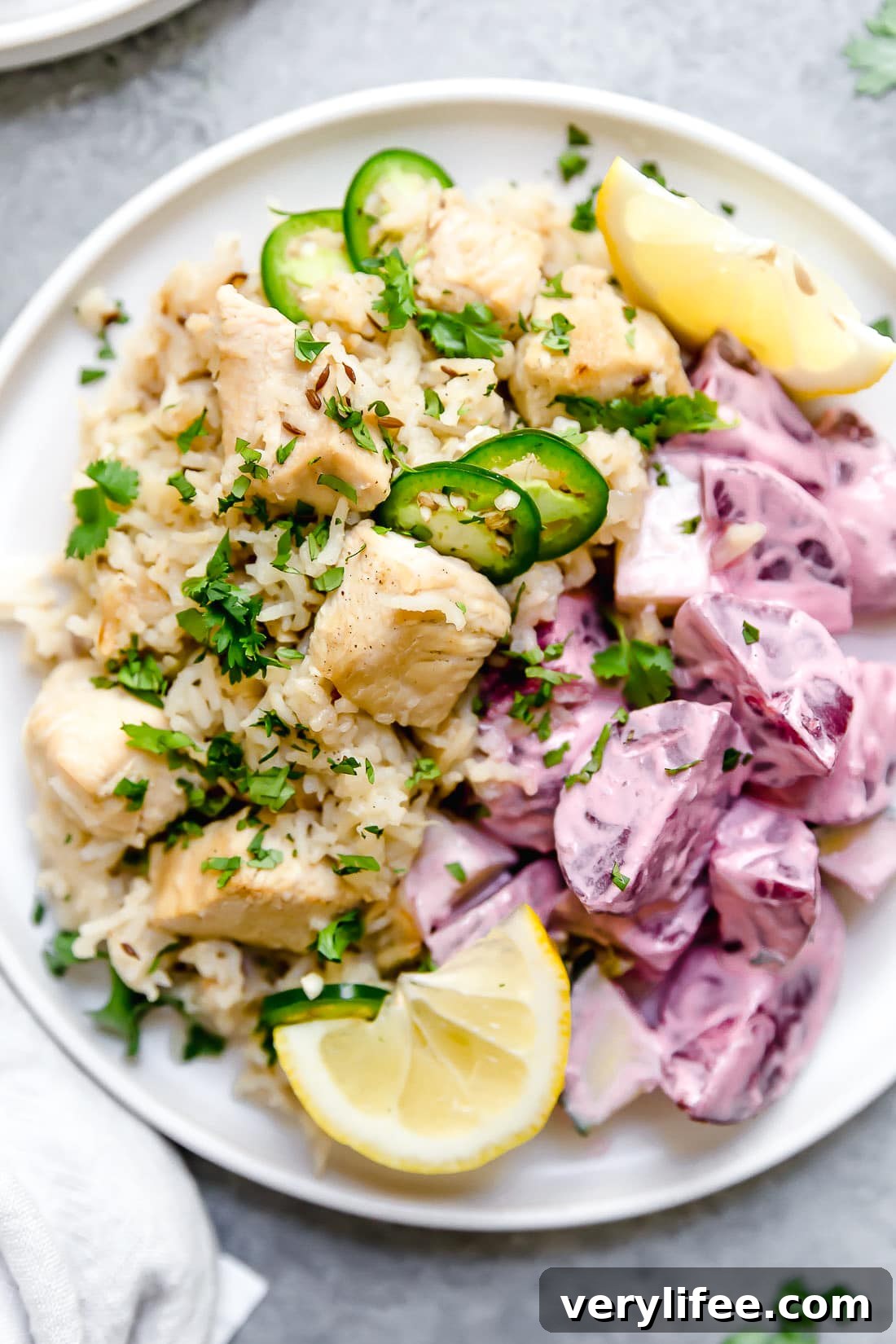 Instant Pot Chicken Pulao comes together in just 30 minutes, with basmati rice, chicken breasts, and a few aromatics and spices. A plate of chicken pulao topped with sliced chiles and lemon wedges