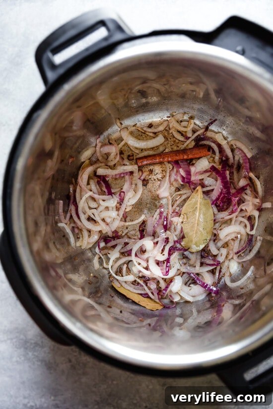 Sliced onion and spices in an Instant Pot Sliced onion and spices in an Instant Pot