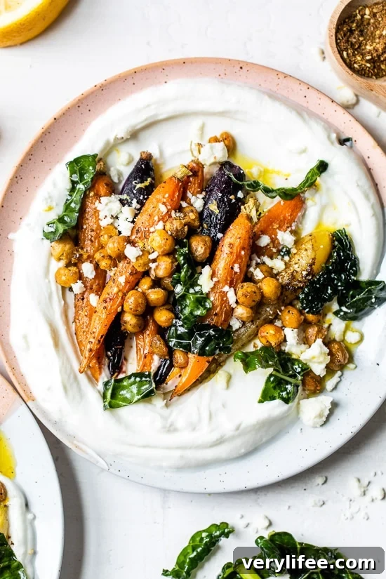 Roasted Carrots and Chickpeas seasoned with za’atar and served over Greek yogurt with lemony kale makes a wonderful side dish or meatless main!