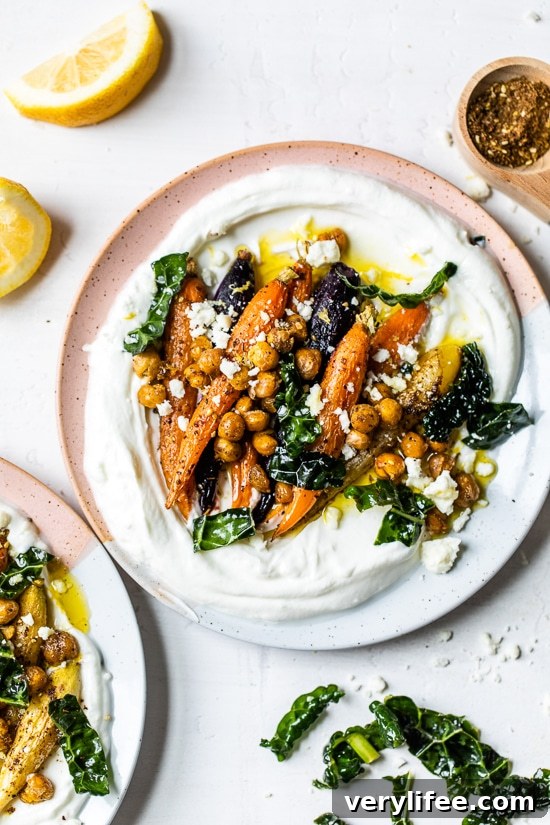 Roasted Carrots and Chickpeas seasoned with za’atar and served over Greek yogurt with lemony kale makes a wonderful side dish or meatless main!