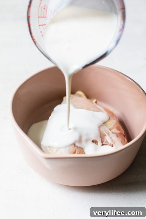 pouring buttermilk on chicken breast