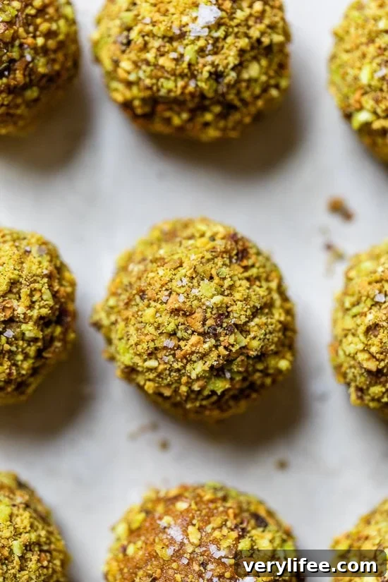 Made with cashews, pistachios, dates, pumpkin and spices, these no-bake Pumpkin Pistachio Energy Balls taste like little bites of pumpkin pie. Pumpkin Pistachio Energy Balls on a baking sheet