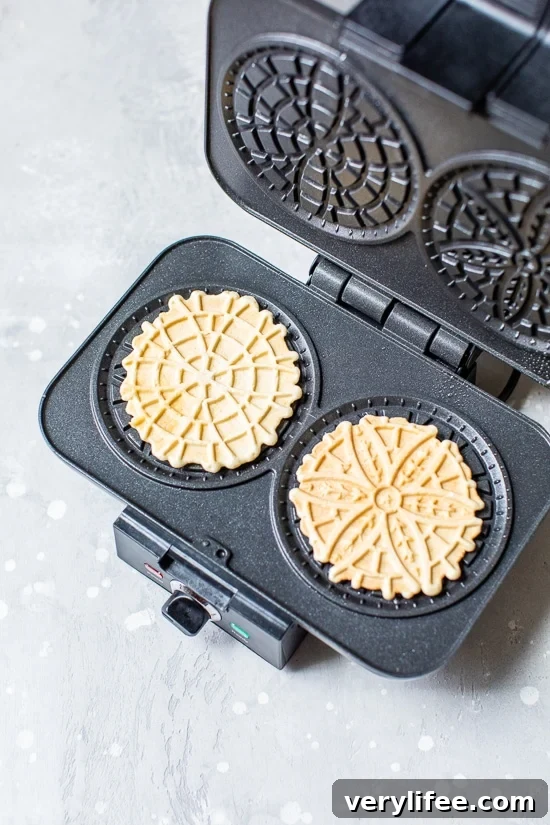 Authentic Italian Pizzelle Cookie Recipe 4 Pizzelle Cookies in a pizzelle press.