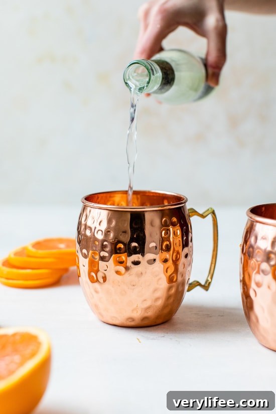 pouring ginger beer into copper mug