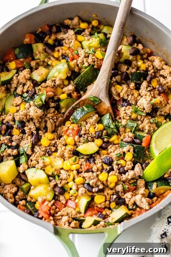 Ground Turkey with Zucchini, Corn, Black Beans and Tomatoes in a skillet.
