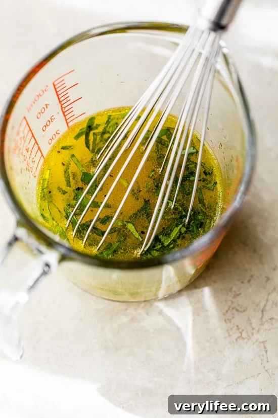 Citrus dressing in a measuring cup with a whisk.