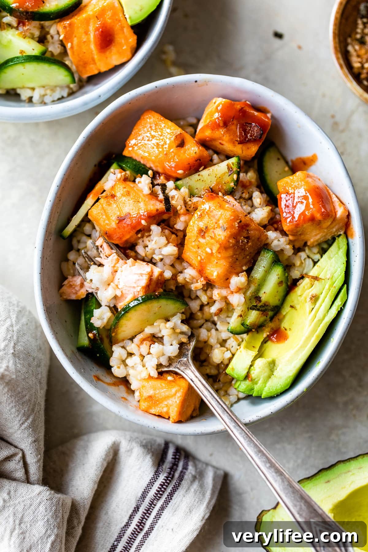 Honey Sriracha Roasted Salmon Rice Bowls (GF, Dairy-Free) 3 Honey Sriracha Roasted Salmon Bowls with a fork