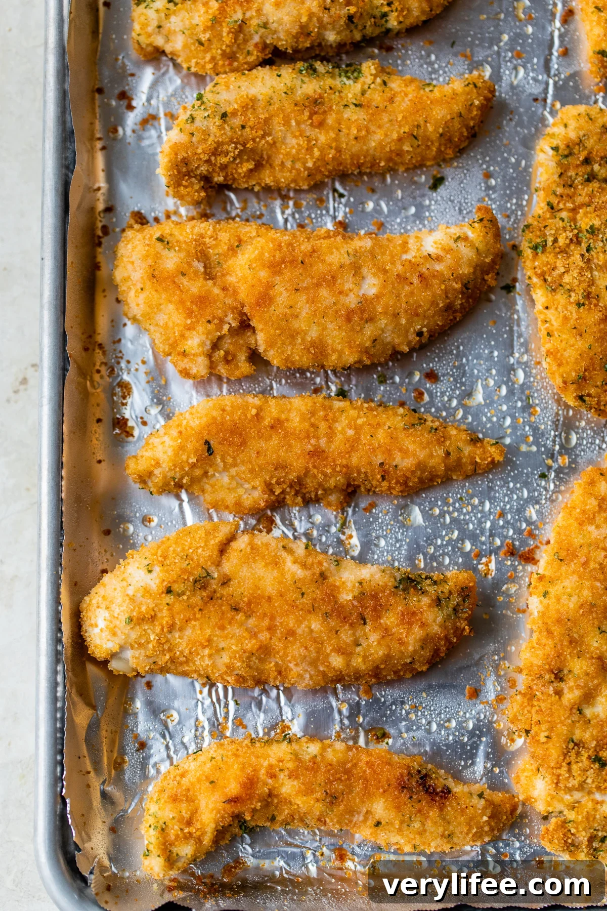 Baked chicken tenderloins on a baking sheet Baked chicken tenderloins on a baking sheet