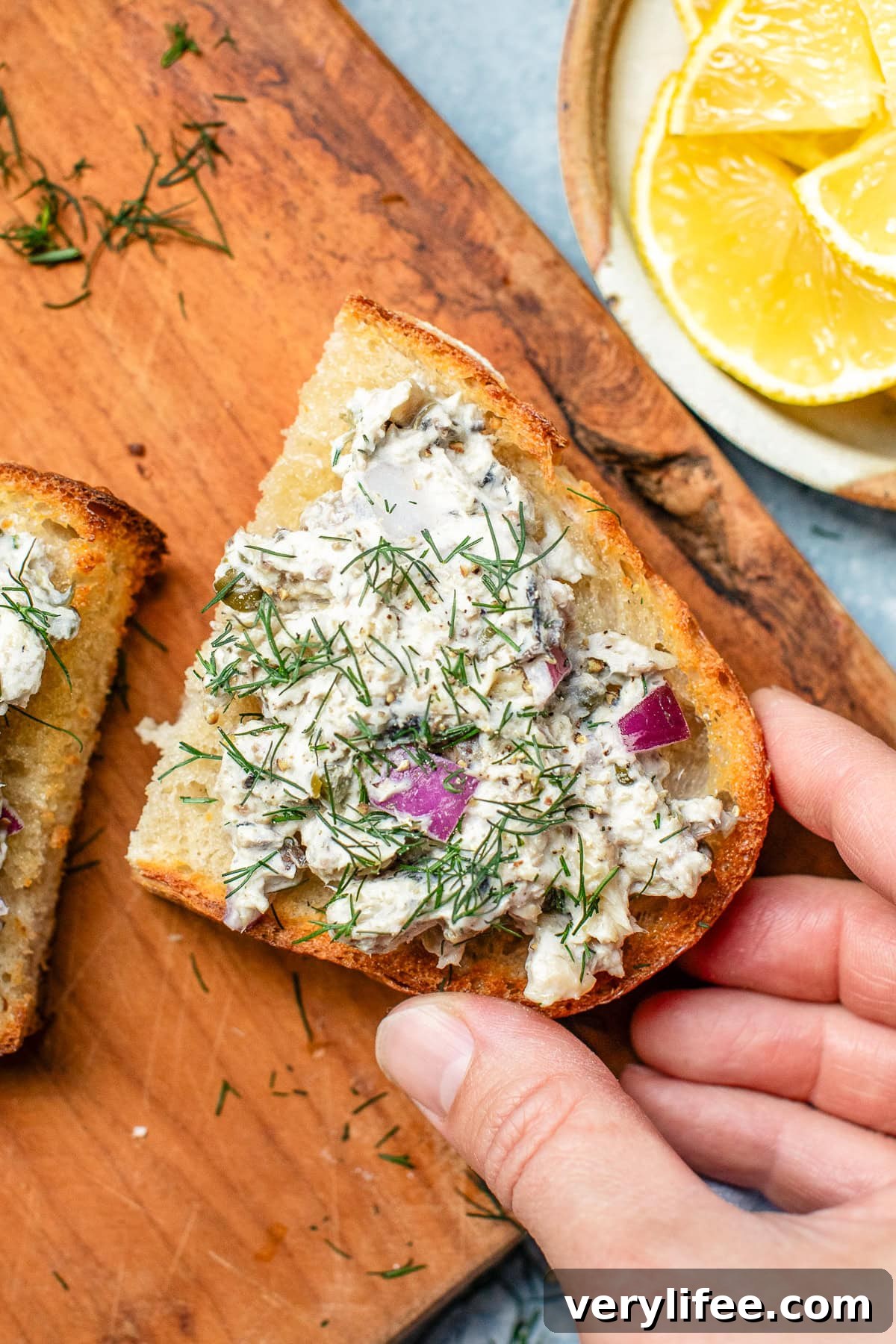 Sardine Salad Recipe with Lemon, Capers and Olive Oil 8 Sardine Salad on toast with a hand